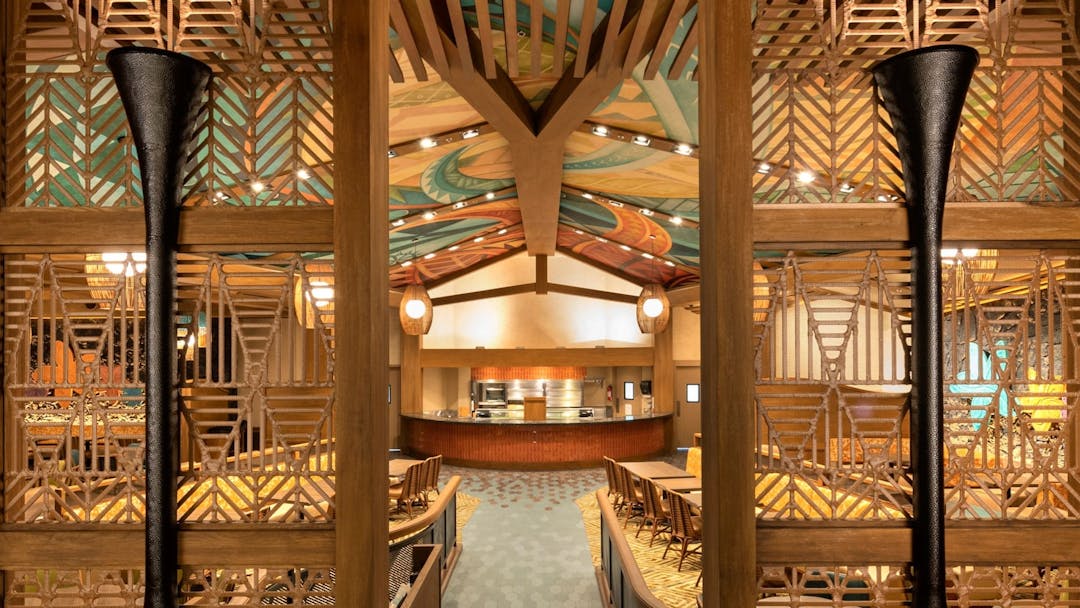 Dining hall with Polynesian inspired architecture including a ceiling mural and natural wood accents